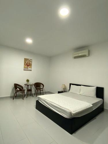 a bedroom with a bed and a table and chairs at Maria Hotel in Ba Tri