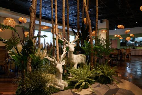 two statues of deer in a room with plants at Aspire Resort in Longtan