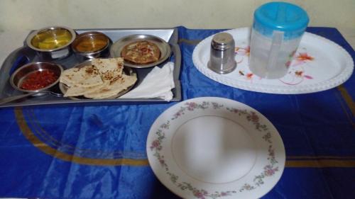 a table with a tray of food and a plate of food at Haranya Homestay in Hatton