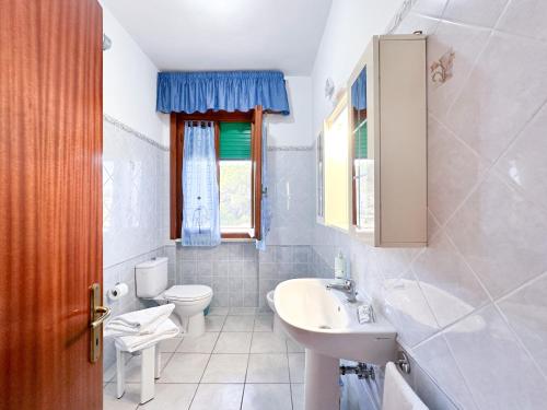 a white bathroom with a sink and a toilet at Agriturismo La Rondine in Bolgheri