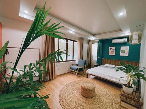 1 dormitorio con 1 cama y una planta grande en D Home Sapa, en Sa Pa