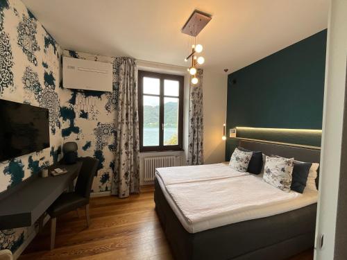 una camera con letto, scrivania e finestra di Arbostora Charme Hotel a Morcote