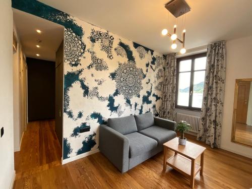 a living room with a couch and a wall mural at Arbostora Charme Hotel in Morcote