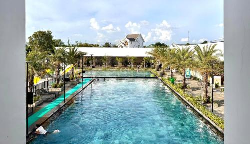 a large pool with blue water and palm trees at Sens Club in Thốt Nốt