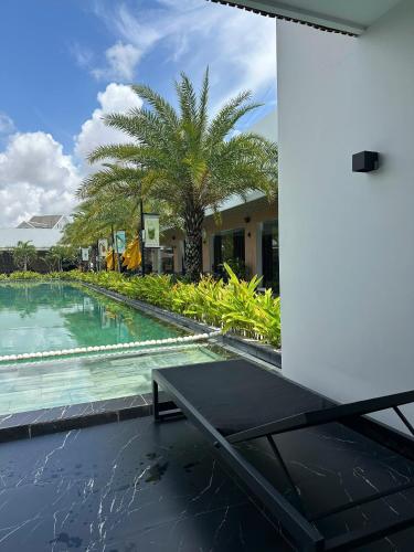 a pool with a table in front of a building at Sens Club in Thốt Nốt