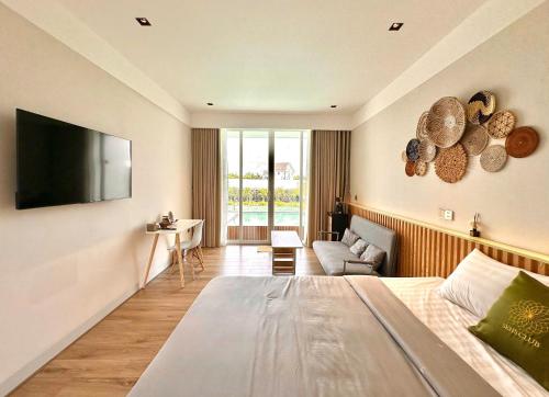 a bedroom with a large bed and a living room at Sens Club in Thốt Nốt