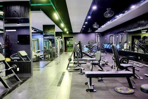 a gym with treadmills and machines in a room at Sens Club in Thốt Nốt