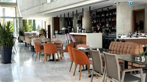 a restaurant with tables and chairs and a bar at Elysia Park Premium in Paphos City