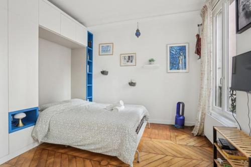 une chambre blanche avec un lit et une télévision dans l'établissement DesignAppart - Île Saint-Louis, Notre-Dame, Marais, à Paris