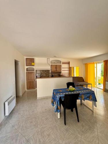 un salon avec une table et une cuisine dans l'établissement Maison bord de mer Eze, à Èze