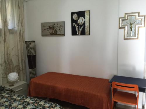 a bedroom with two beds and a cross on the wall at Holiday Home Gionny & Mary in Taormina