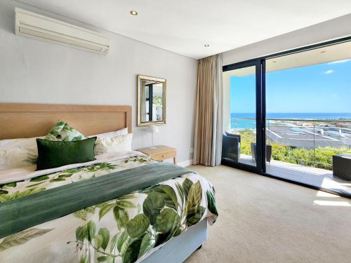 a bedroom with a bed and a large window at Blue Emerald Villa in Cape Town