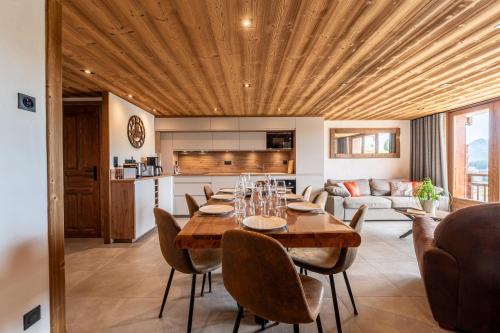 une salle à manger avec une table et des chaises et une cuisine dans l'établissement Appartements Les Saisies Hautlieux, à Hauteluce