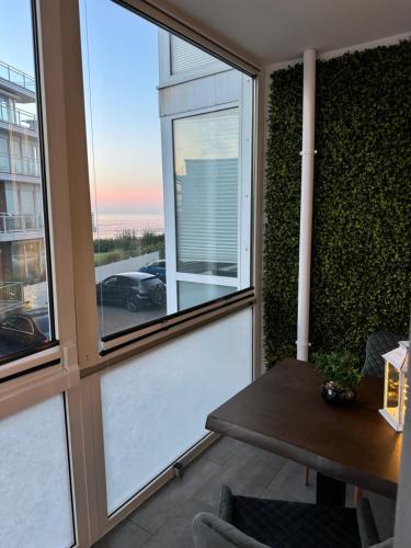 a living room with a table and a window at Strandjuwel in der Seehütte Cuxhaven Duhnen- Exclusive Ferienwohnung am Strand mit Meerblick in Cuxhaven