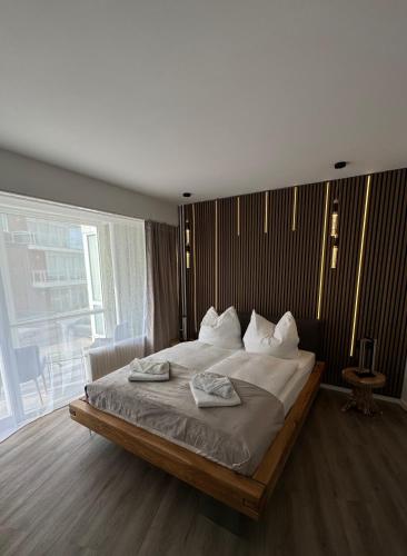 a bedroom with a large bed with two towels on it at Strandjuwel in der Seehütte Cuxhaven Duhnen- Exclusive Ferienwohnung am Strand mit Meerblick in Cuxhaven