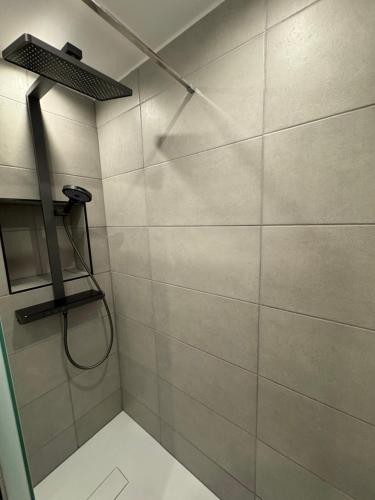 a bathroom with a shower with a shower head at Strandjuwel in der Seehütte Cuxhaven Duhnen- Exclusive Ferienwohnung am Strand mit Meerblick in Cuxhaven