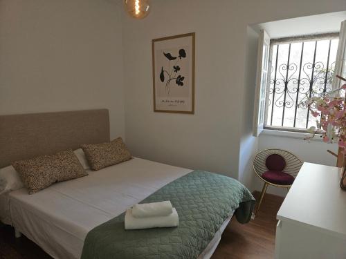 a small bedroom with a bed and a window at Apartamentos Mirador de San Telmo in Tui