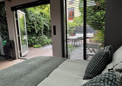 a bedroom with a bed in front of a sliding glass door at City Oasis with private parking in The Hague