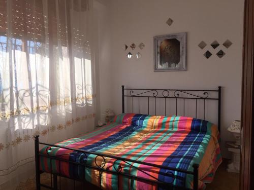 a bed with a colorful comforter in a bedroom at Holiday Home Gionny & Mary in Taormina
