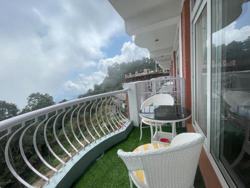 a balcony with chairs and a table on a building at Mountain Vista Retreat in Nagarkot