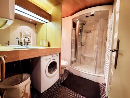 une salle de bain avec un lavabo et une machine à laver dans l'établissement 60m2 cœur station Esprit Montagne et skis aux pieds, à Huez