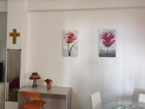 three paintings of pink flowers on a wall at Holiday Home Gionny & Mary in Taormina