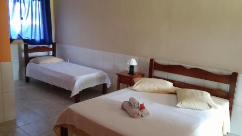 een slaapkamer met 2 bedden en handdoeken bij Forte Do Pouso Hospedagens in Saquarema
