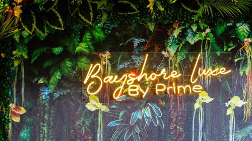 a neon sign on a wall with plants at Luxury Condo Ocean View 1,2,3, & 4 Bedrooms Infinity Pool Gym Spa Next to Okada Solaire MOA NAIA Airport in Manila