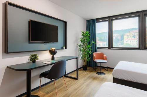 a hotel room with a desk and a tv at CX Trieste Giulia in Trieste