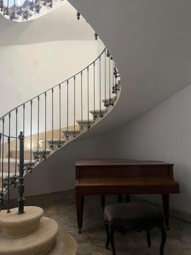 a stairway with a bench and a piano at Château de Taulignan in Saint-Marcellin-lès-Vaison