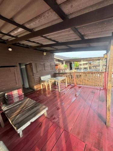 a porch with a bench and a table on a deck at Tonmai Suite II in Ko Por