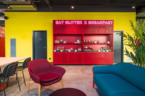 a restaurant with a red and yellow wall and a table and chairs at CX Trieste Giulia in Trieste