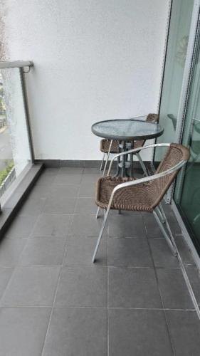 a patio with a table and chairs on a balcony at Countryside Condo @One Residence Sekinchan in Sekincan