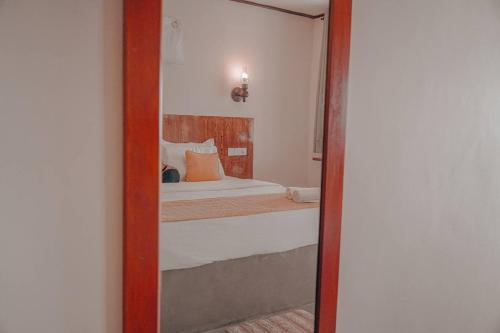 een spiegel die een slaapkamer reflecteert met een bed erin bij MANTA RAY MANOR HAVEN -Nestled on Sri Lanka's Southern Coast, offers Luxurious rooms with Ocean, Garden, & Pool Views, a Private Beach, Ocean-View Pool with a Jacuzzi, & Event Hosting & more, your Perfect Escape for Relaxation & Unforgettable Moments in Ahangama