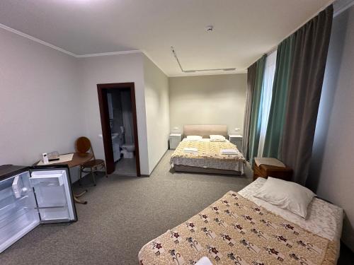 a hotel room with two beds and a window at Ресторан-Готель Шеркерт in Berehove
