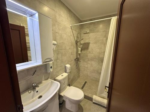 a bathroom with a toilet and a sink and a shower at Ресторан-Готель Шеркерт in Berehove