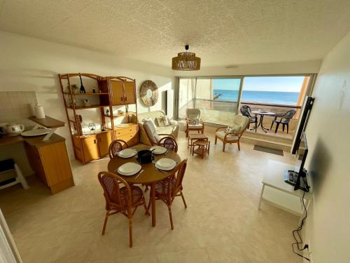 un salon avec une table et des chaises et l'océan dans l'établissement Appartement vue mer T2 de 51m2 avec 1 chambre, à Saint-Jean-de-Monts