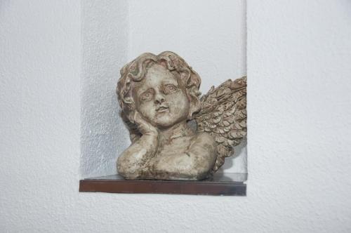 una estatua de un ángel sentado en un estante en Appart Loreen, en Niederthai