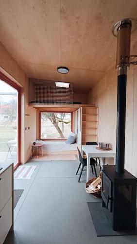 a room with a stove and a dining room with a table at Tiny house v ohradě in Čížkov