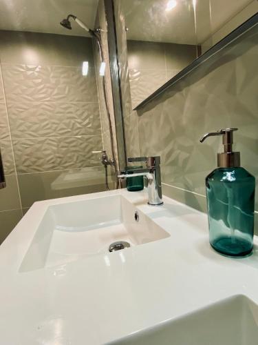 un lavabo de salle de bain avec un distributeur de savon dessus dans l'établissement Le Loft de l Horloge, à Lescure-dʼAlbigeois