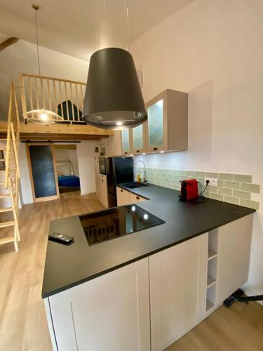 une cuisine avec un comptoir noir dans une pièce dans l'établissement Le Loft de l Horloge, à Lescure-dʼAlbigeois