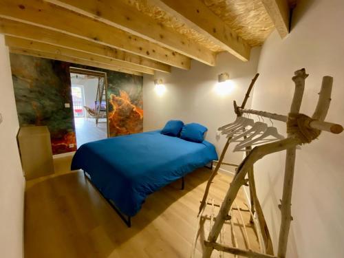 a bedroom with a blue bed and a ladder at Le Loft de l Horloge in Lescure-dʼAlbigeois