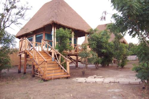 a small hut with a staircase and a thatched roof at Entale Safari Camp Queen Elizabeth National Park in Kasese