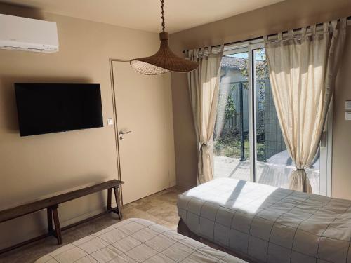 une chambre avec un lit, une télévision et une fenêtre dans l'établissement Maison Individuelle, à Polliat