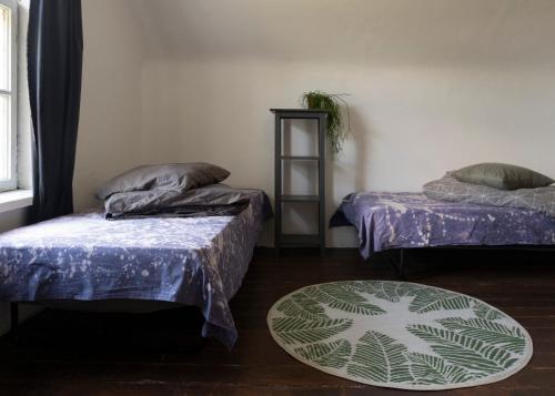 a room with two beds and a rug at MILK HOUSE- Laidi Palace residency in Laidi