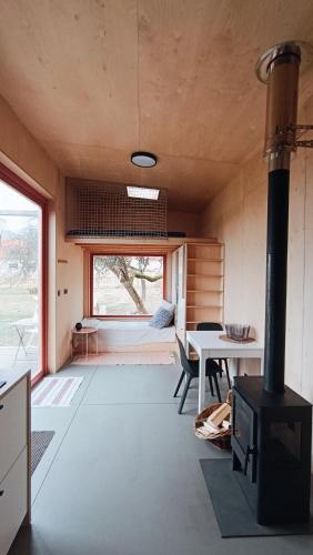 a room with a stove and a table and a bedroom at Tiny house v ohradě in Čížkov