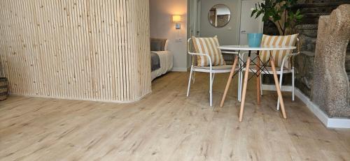 a room with a table and chairs and a bed at Apartamentos Mirador de San Telmo in Tui