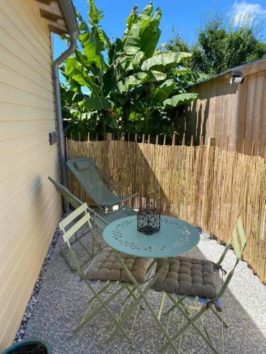 a patio with a table and two chairs and a fence at entre terre et mer in Sainte-Soulle