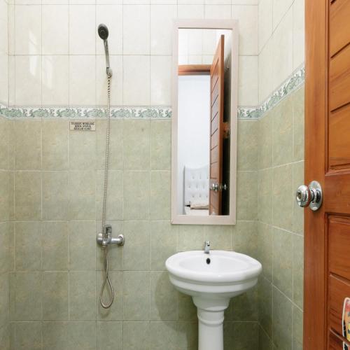 a bathroom with a sink and a shower at RedDoorz near Trans Studio Mall Cibubur in Depok