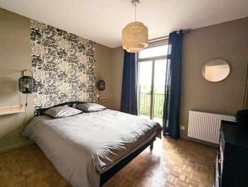 een slaapkamer met een bed en een groot raam bij Sylonie in Châteauroux